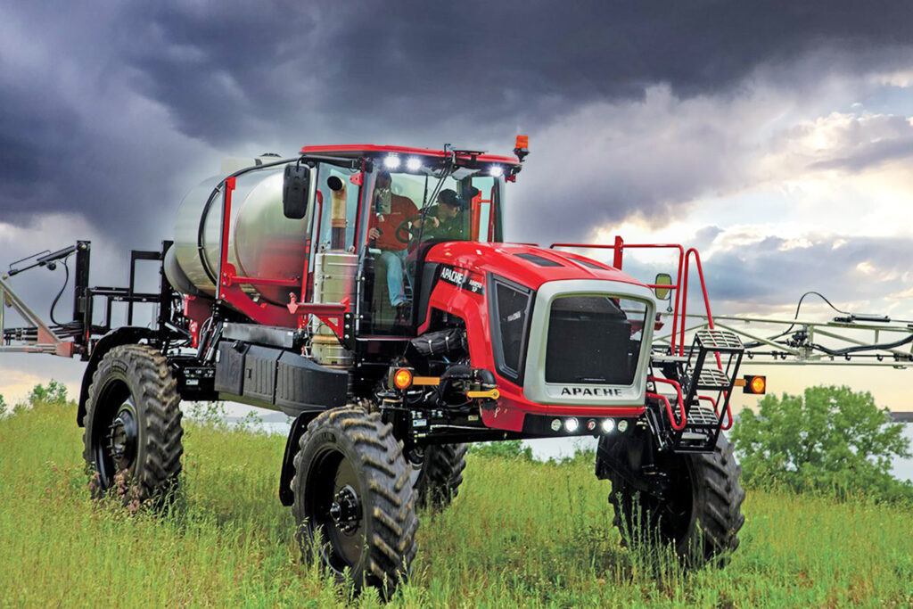 Apache AS1250 sprayer in field with rain clouds overhead