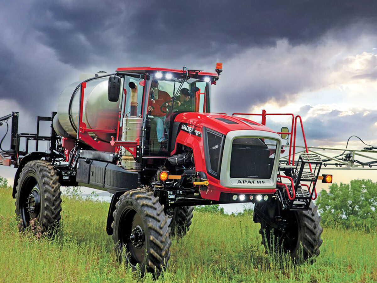 Apache AS1250 sprayer in field with rain clouds overhead