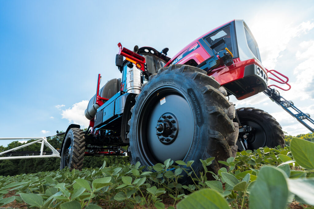 on ground looking up at apache sprayer from front side angle